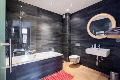 a bathroom with a tub and a toilet and a sink at B&B Quatre20cinq in Antwerp