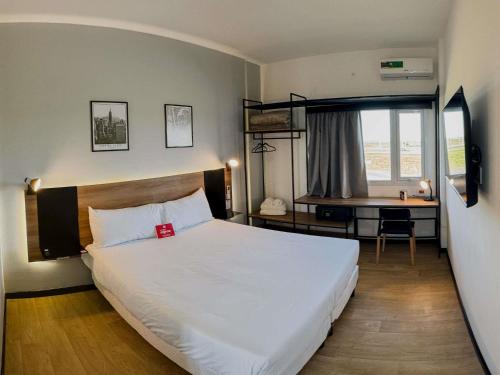 a bedroom with a large white bed and a desk at Ibis Puerto General San Martin in San Lorenzo