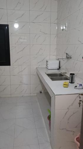 a white bathroom with a sink and a counter at GALSEN LODGe in Thiès