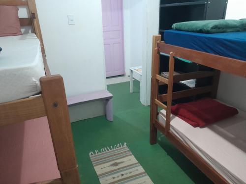 a room with two bunk beds and a green floor at Fênix in Porto Velho