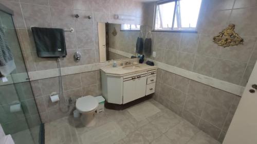 a bathroom with a toilet and a sink and a mirror at Varanda do forte in Cabo Frio