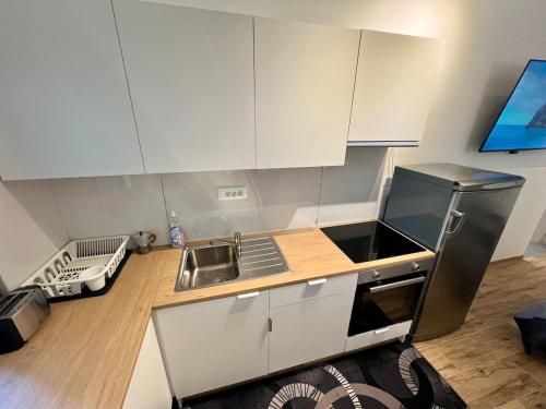 a kitchen with white cabinets and a sink at Apartment Edi in Grgar