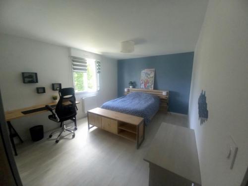 a bedroom with a bed and a desk and a chair at Villa kerneing in Fouesnant