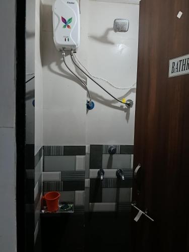 a bathroom with black and white tile on the wall at Viresh Cottage in Solapur