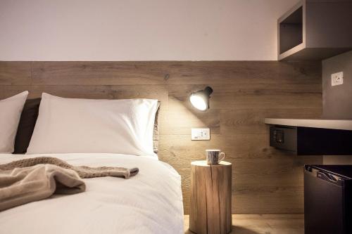 a bedroom with a white bed with a wooden wall at Casa Alla Lega in Arco