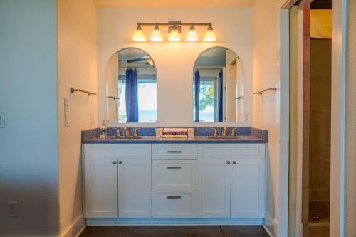 a bathroom with two sinks and two mirrors at Salty Bay Hideaway in Gulf Breeze