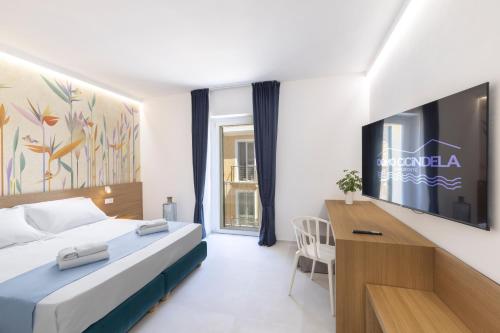 a hotel room with a bed and a desk at Domo Cicindela Boutique Rooms Centro Carloforte in Carloforte