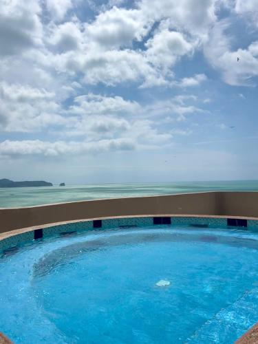 a swimming pool with the ocean in the background at Cozy suite and Jacuzzi overlooking the ocean in Volcán Chimborazo