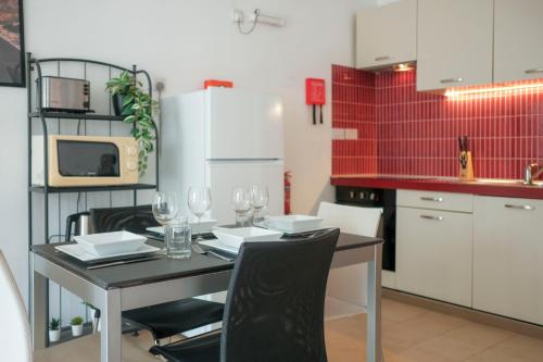 a kitchen with a table with wine glasses on it at Porto by Shmoo! in Is-Swieqi