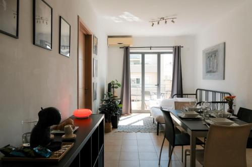 a living room with a table and a dining room at Porto by Shmoo! in Is-Swieqi