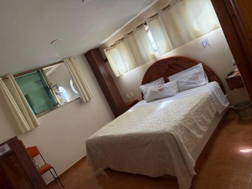 a bedroom with a large bed with white sheets and pillows at HOTEL MIGUEL ÁNGEL in Progreso de Obregón