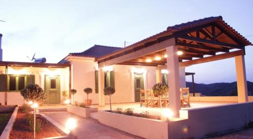 a house with an outdoor patio at night at Augusta Country House in Derés