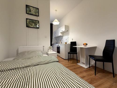 a bedroom with two beds and a table and a kitchen at Chińczyk in Inowrocław