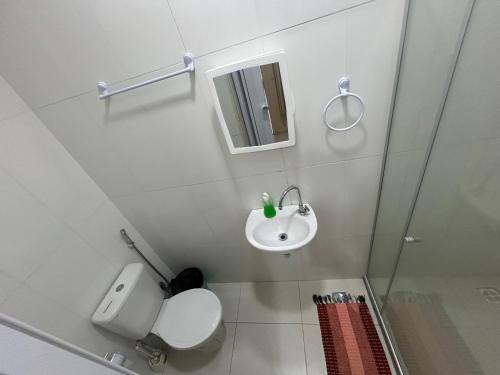 a small bathroom with a toilet and a sink at Village enseada do castelo-com carregador de carros eletricos in Praia do Forte