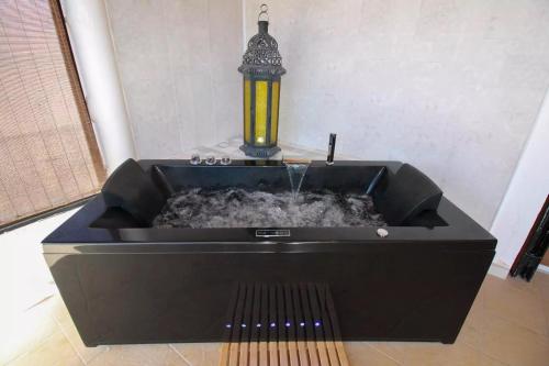 a black bath tub with a water fountain at Studio Walla Confort Centre in Montbrun-les-Bains
