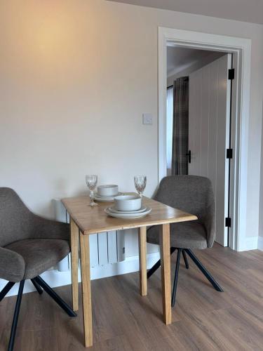a wooden table with two chairs and glasses on it at Meadow View in Birr