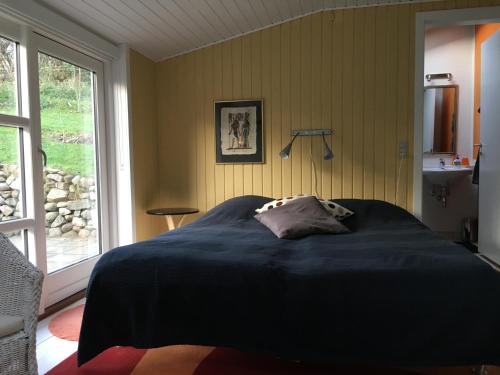 a bedroom with a large bed in a room with a window at Heltoften Bed & Breakfast in Nykøbing Mors