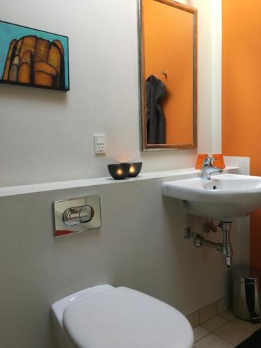 a bathroom with a white toilet and a sink at Heltoften Bed & Breakfast in Nykøbing Mors