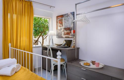 a bedroom with a desk with a laptop and a window at Lithinon House in Chania