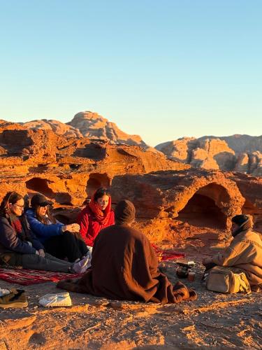 Desert Time في وادي رم: مجموعة من الناس يجلسون على قمة جبل