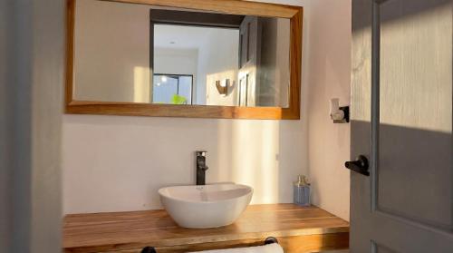 a bathroom with a white sink and a mirror at Aduana House in Santa Teresa Beach