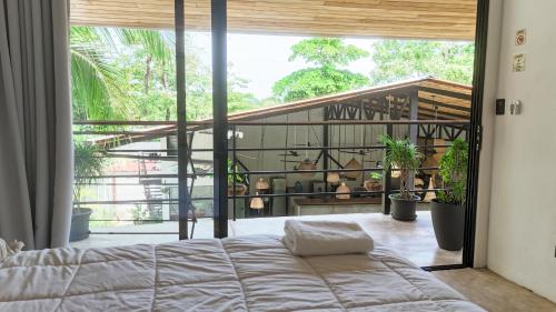 a bedroom with a bed and a large window at Aduana House in Santa Teresa Beach