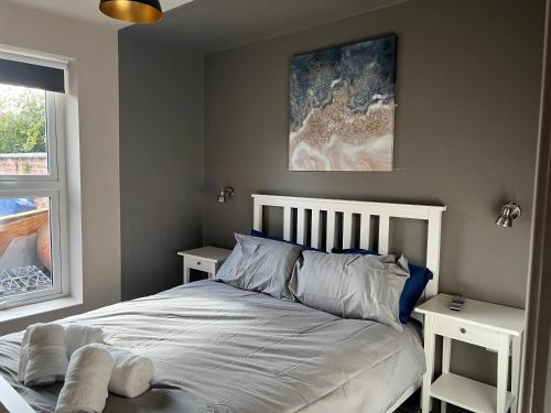 a bedroom with a bed with two nightstands next to a window at Spacious 3 Bed Apartment Sleeps 8 Parking Garden in Loughborough in Loughborough