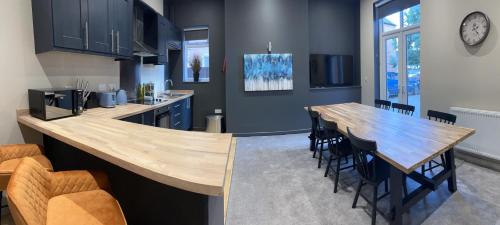 a kitchen with a large wooden table and chairs at Spacious 3 Bed Apartment Sleeps 8 Parking Garden in Loughborough in Loughborough