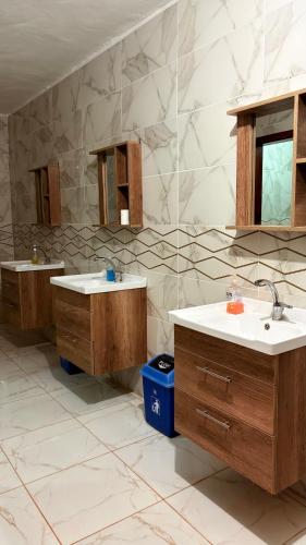 een badkamer met twee wastafels en twee spiegels bij Desert Time in Wadi Rum