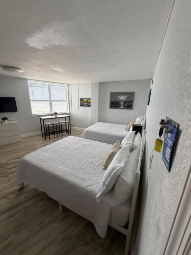 a bedroom with two beds and a table in it at Beach Front Resort with Ocean View in Daytona Beach