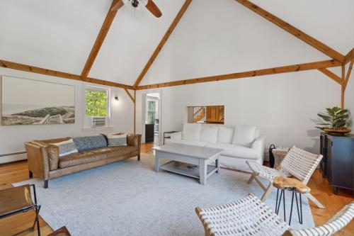 a living room with a couch and a table at Wildflower Retreat in Kennebunk