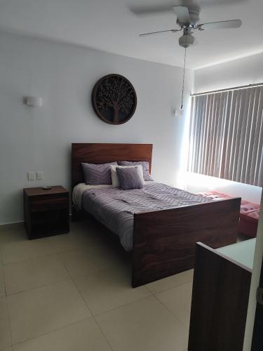 a bedroom with a bed and a clock on the wall at Departamento en renta vacacional nuevo Vallarta puerta del valle Valle dorado in Nuevo Vallarta