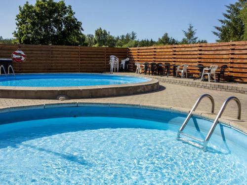 a swimming pool in a backyard with chairs and tables at DCU-Camping Tranum in Brovst