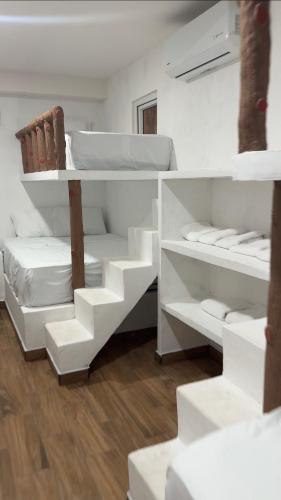 a white room with white shelves and a bed at Monterrico VIP in La Candelaria