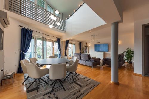 a living room with a table and chairs at Villa Poljine GREEN in Sarajevo