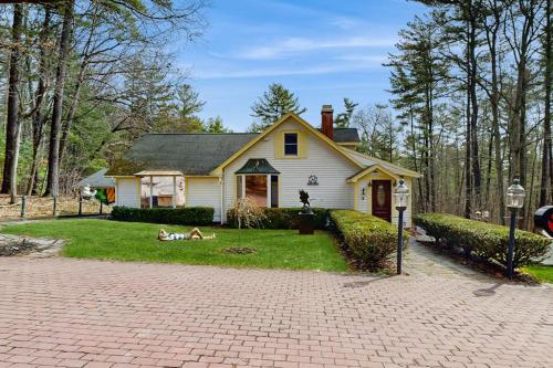 a white house with two dogs laying in the yard at Hidden Haven in Bath