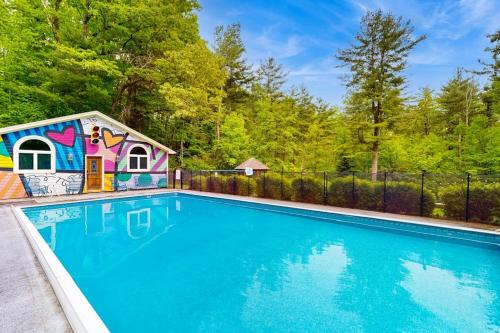 a swimming pool with a toy house next to a fence at Hidden Haven in Bath