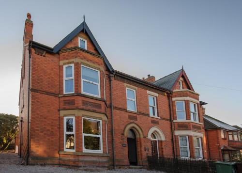 an old red brick house with white windows at Spacious 3 Bed Apartment Sleeps 8 Parking Garden in Loughborough in Loughborough