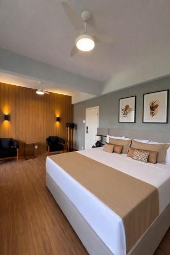 a bedroom with a large white bed in a room at Imperador Hotel in Poços de Caldas