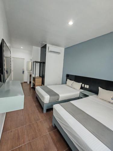 a hotel room with two beds and a room with at Aló Select Mazatlan in Mazatlán