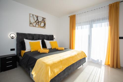 a bedroom with a large bed with yellow pillows at Villa Vox in Labin