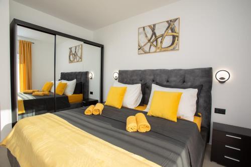 a bedroom with a large bed with yellow pillows at Villa Vox in Labin