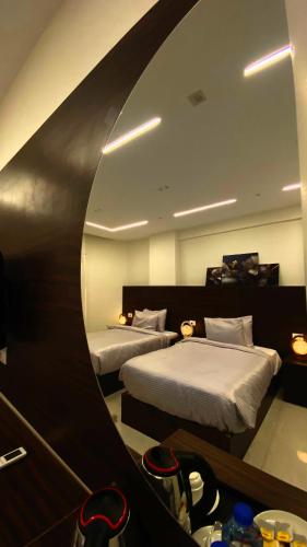 a hotel room with two beds and a mirror at Makan Pyramids View in Cairo
