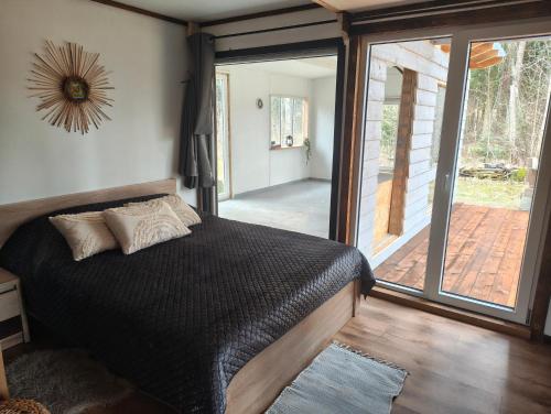 a bedroom with a bed and a sliding glass door at Dreamcatcher in Straupe