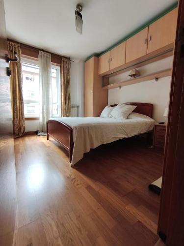 a bedroom with a large bed and a window at Ale Galicia in Cambre