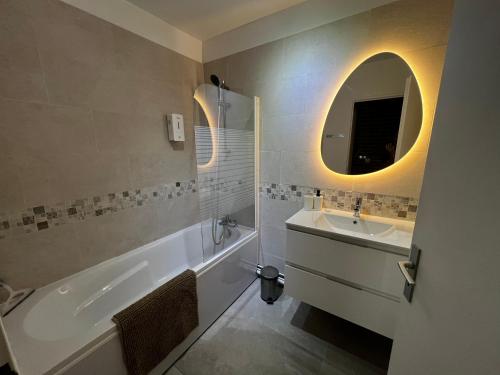 a bathroom with a tub and a sink and a mirror at Ulis très beau 2 pièces tout équipé in Les Ulis