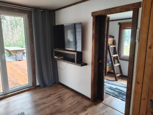 a living room with a flat screen tv on a wall at Dreamcatcher in Straupe