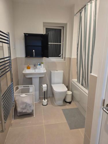 a bathroom with a toilet and a sink and a tub at HomeAway Comfort in Minster
