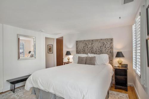 a white bedroom with a large bed and two lamps at Charming Rowhome in Downtown Annapolis in Annapolis