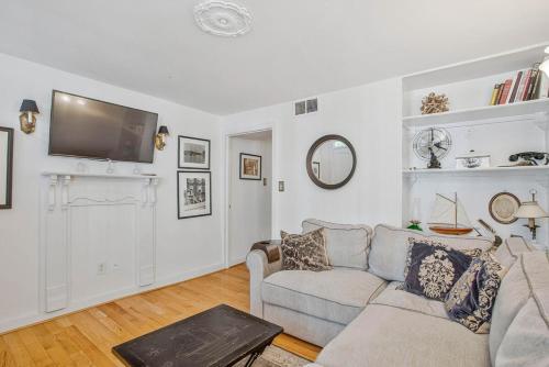 a living room with a couch and a tv on the wall at Charming Rowhome in Downtown Annapolis in Annapolis